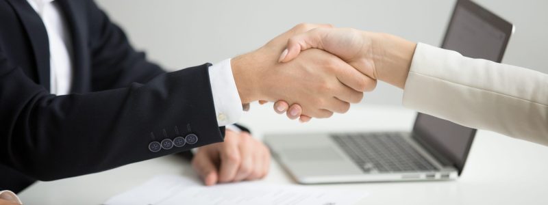 Employment handshake concept, female hr and successful woman candidate shaking hands getting hired ready to sign job contract concept, employer congratulating welcoming new worker, close up view